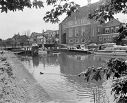 857882 Gezicht op de IJsselpoort en het stadhuis van Montfoort, met op de voorgrond de Hollandsche IJssel.